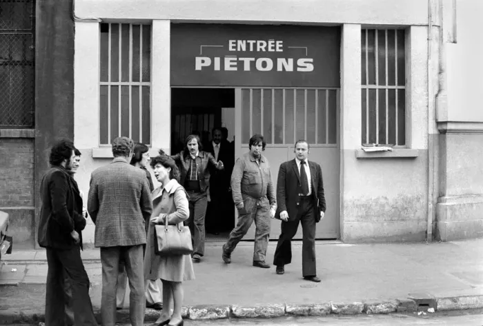 Framed Print : Renault factory workers leaving at the end of a shift through a door marked Framed Print : Renault factory workers leaving at the end of a shift through a door marked