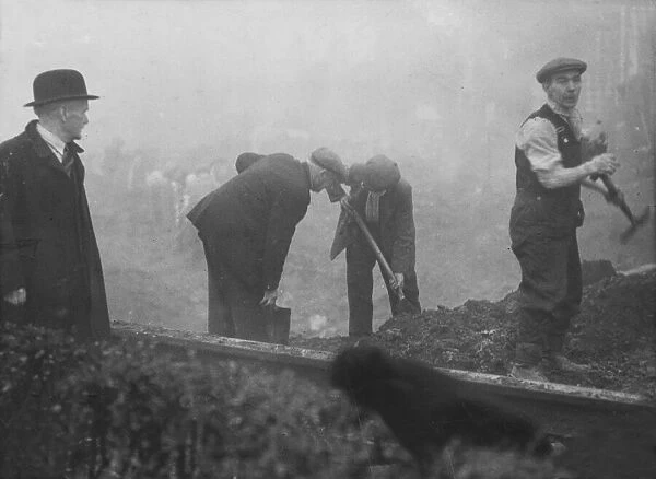 Repair squads at work in Liverpool, Merseyside, in filling up a crater caused by a Nazi