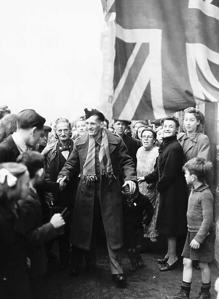 A repatriated British airman is welcomed home by friends and neighbours during WW2 1943