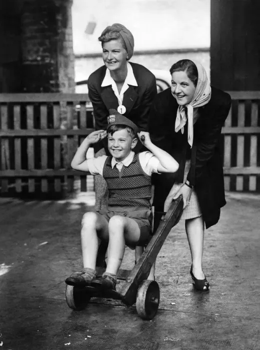 Framed Print : Repatriated civilians. A boy on a sack truck with two girls pushing