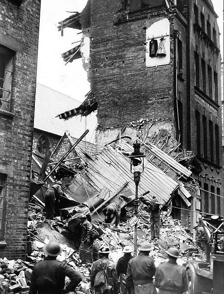 Rescue workers search the rubble after a London office block was hit during a WW2 German