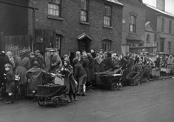 Residents of Birmingham queue with their prams at the Coal Merchants in Green Lane