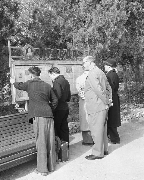 Residents read the official soviet newspaper Izvestia from a public noticeboard in a