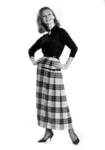 Reveille Fashions 1964. Mannequin modeling a blouse and full length tartan skirt