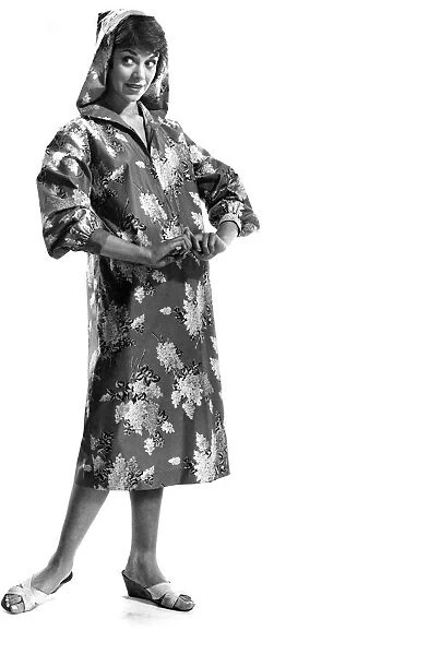 Reveille Fashions. Model wearing floral pattern hooded rain coat. April 1959 P006944