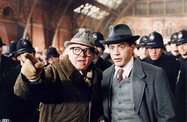 Richard Attenborough with Robert Downey Jnr and extras on station set of film Charlie