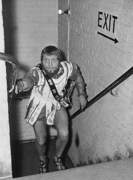 Richard Attenborough wearing Greek costume running up stairs backstage at the Piccadilly
