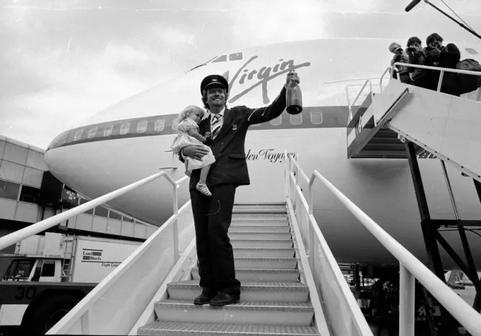 Framed Print : Richard Branson holding a bottle of champagne and his daughter on the steps of Framed Print : Richard Branson holding a bottle of champagne and his daughter on the steps of
