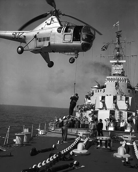 Richard Dimbleby descends from a Westland Dragonfly helicopter on to the deck of HMS