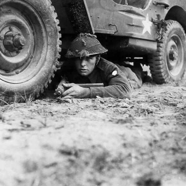 Rifleman Brett of Newport, Isle of Wight, takes cover beneath his vehicle when on look