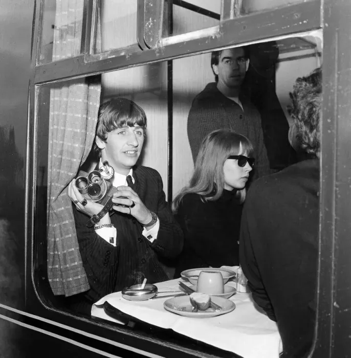 Framed Print : Ringo Starr with a cine camera and an actress in his compartment with the Beatles Framed Print : Ringo Starr with a cine camera and an actress in his compartment with the Beatles