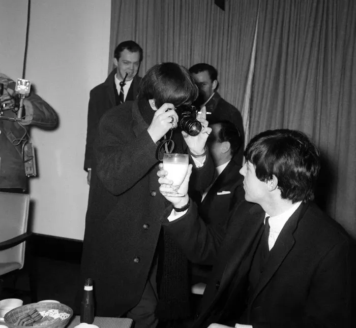 Framed Print : Ringo Starr taking pictures of Paul McCartney holding a glass of milk at Hethrow before