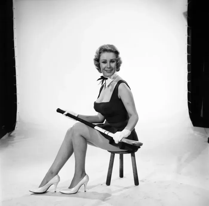 Framed Print : Rita Royce modelling sports kit with hockey stick. Circa 1959