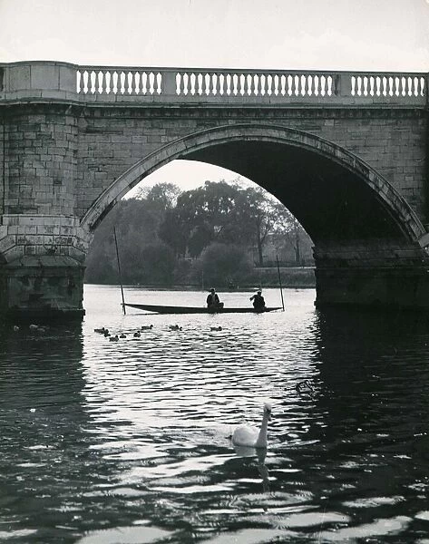 On the river beneath one of the arches of the old Richmond Bridge Surrey Circa