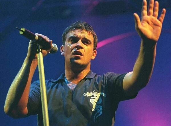 Robbie Williams waves to the audience at his concert at the SECC Glasgow February 1999