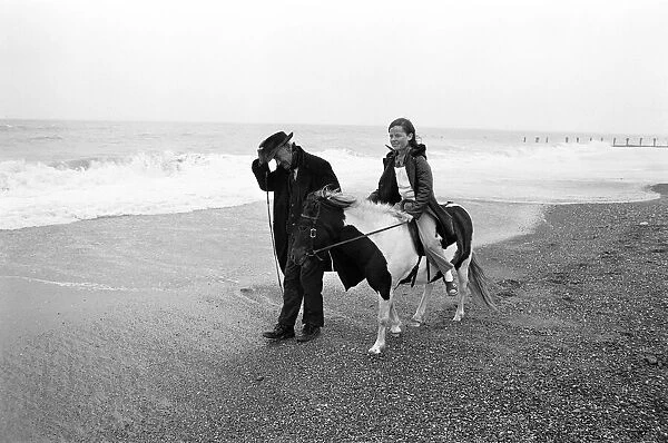 Robert Jackson pony ride owner takes Elizabeth Hood for a ride along a blustery beach at