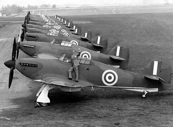 Robert Stanford Tuck, fighter ace from WW2, standing next to a row of hurricanes