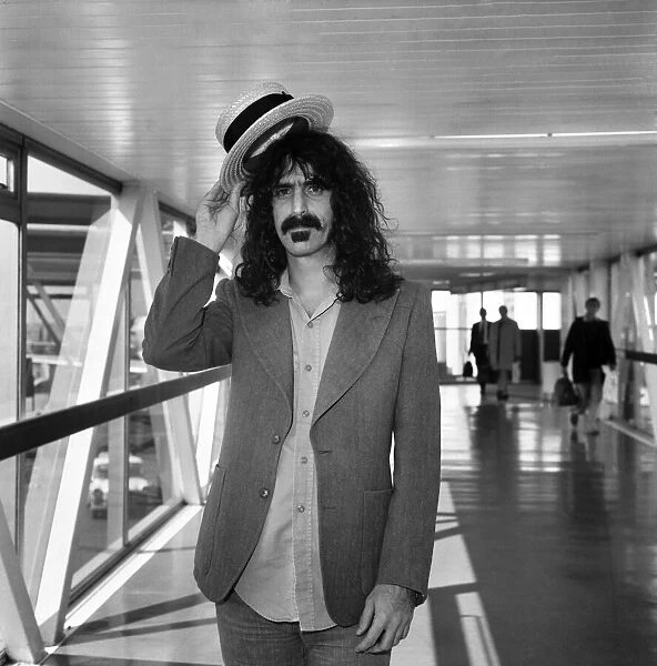 Rock Star Frank Zappa complete with straw boater hat at Londons Heathrow airport