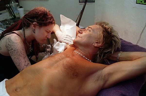 Rod Stewart 21st June 1999 as tattoo artsit Ronda Hoelzer decorates his arm with a