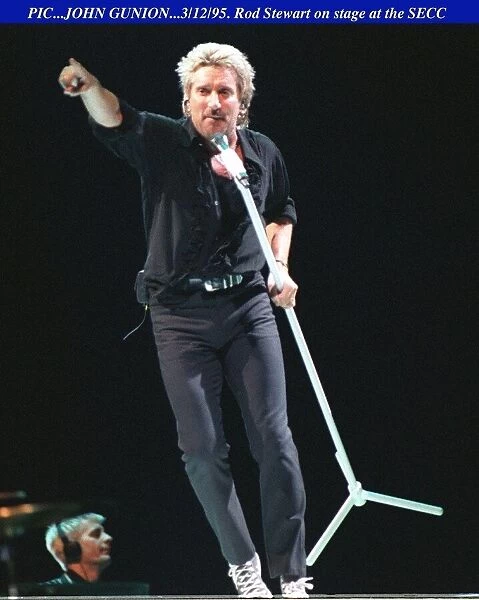 Rod Stewart dancing with the mike on stage at the SECC in Glasgow pointing