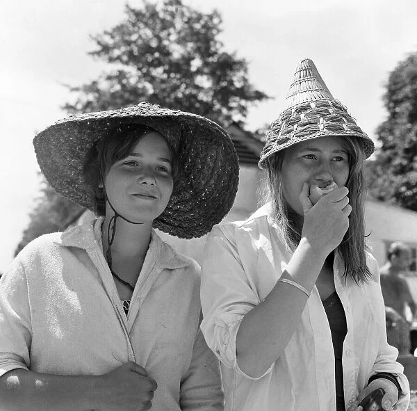 Roehampton swimming pool, London. These two young women with continental straw hats are