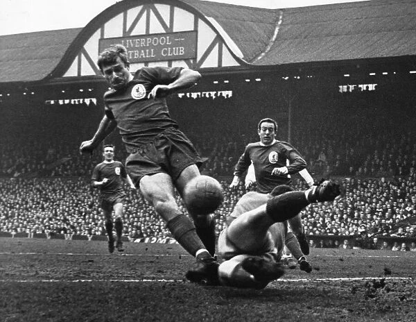 Roger Hunt in action for Liverpool at Anfield, watched by teammate Ian St John during a