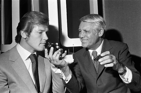 Roger Moore and Cary Grant sample one of their perfumes during their visit to their