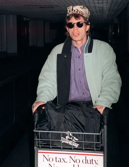 Framed Print : Rolling Stones: Mick Jagger arriving at Heathrow airport pushing trolley in February 1990