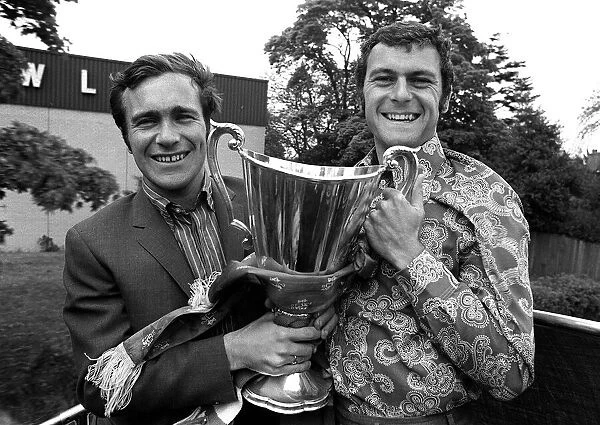 Ron Harris and Keith Weller of Chelsea hold the trophy aboard sn open top bus on a