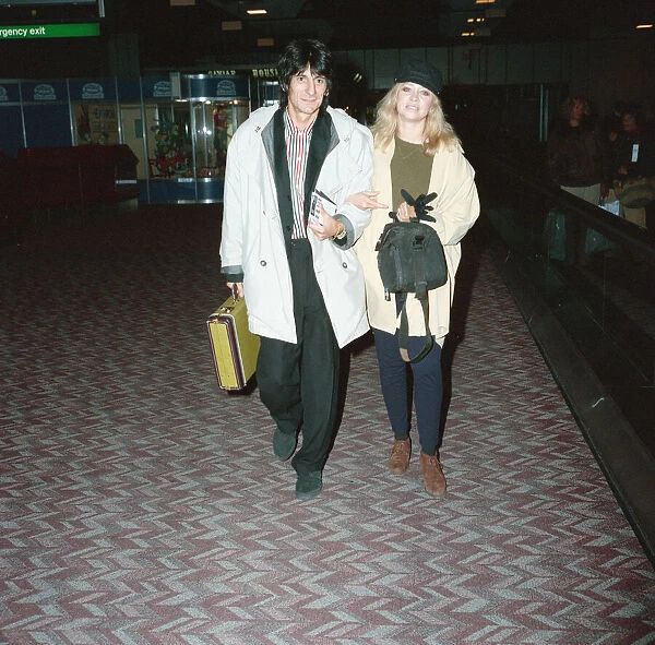 Ronnie Wood and his wife Jo at Heathrow Airport. 28th February 1991