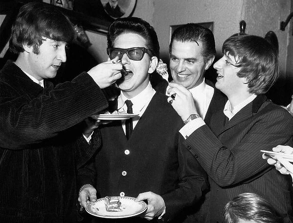 Roy Orbison being fed birthday cake by John Lennon while Ringo Starr looks