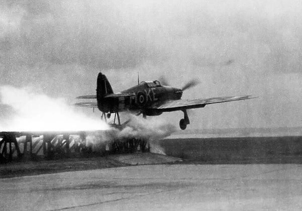 A Royal Air Force Hawker Hurricane is catapaulted down a launching ramp on the bow of a