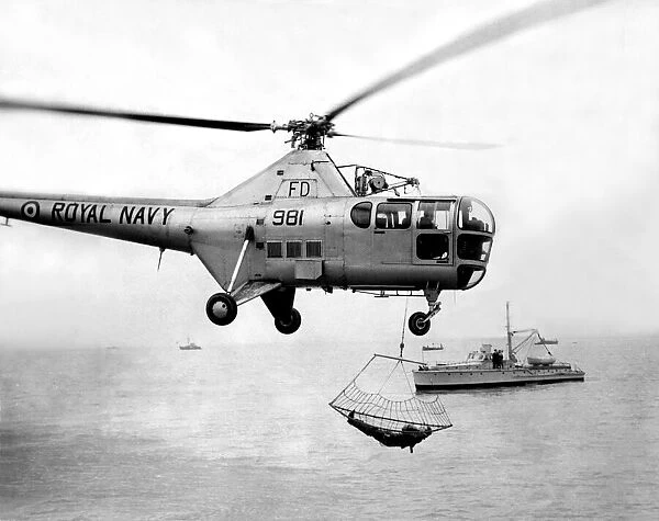 A Royal Navy Westland Dragonfly helicopter uses the newly developed scoop net for picking