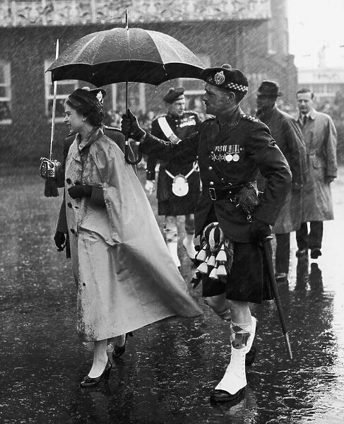 Royal Tour of the Isles. The Queen is drenched as she steps ashore at Oban