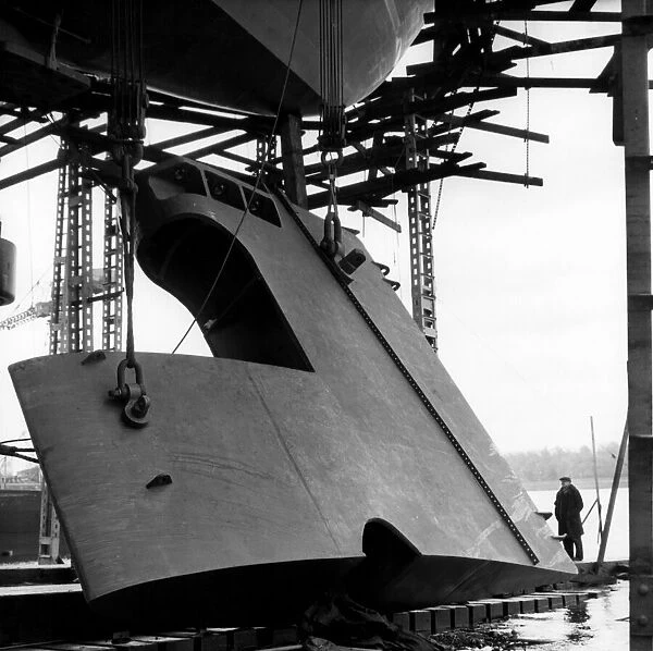 The rudder of the QE2 - bigger than a double decker bus is winched slowly into position
