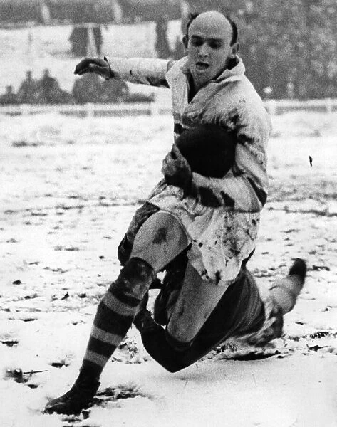 Rugby player Bevan Brian evades a tackle whilst in action in the snow