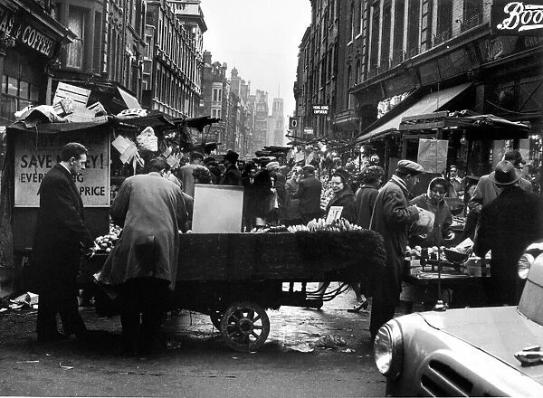 Rupert Street, Soho. Fruit and Veg is sold from a cart outside Boots. Circa 1955