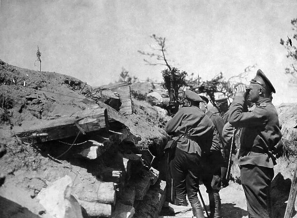 A Russian officer seen watching the movement of the enemy though field glasses whilst a