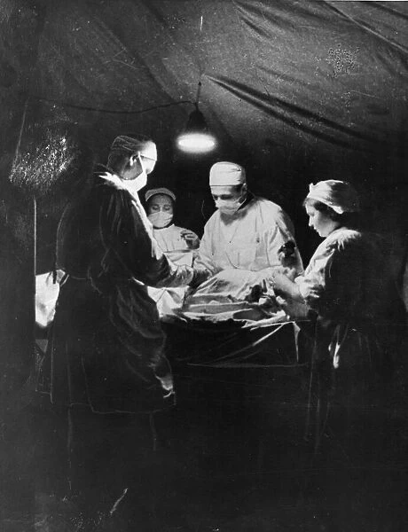 A Russian Surgeon operates on a soldier of the Red Army, in a tent in the snow
