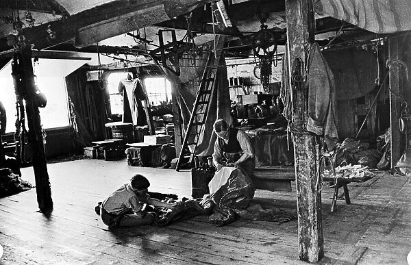 Sailmaker and his apprentice in his work room at Rye. Circa 1910