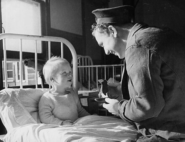 Sailor Gordon Davis of the Royal Navy repais the doll of a patient in the childrens ward