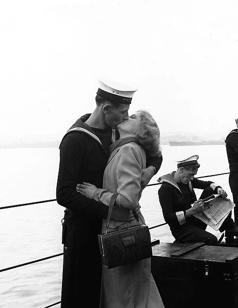 A sailor kisses his girlfriend as the HMS Black Swan returns to England