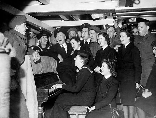 Sailors and soldiers having a sing-song on a British Troopship. 27th February 1944