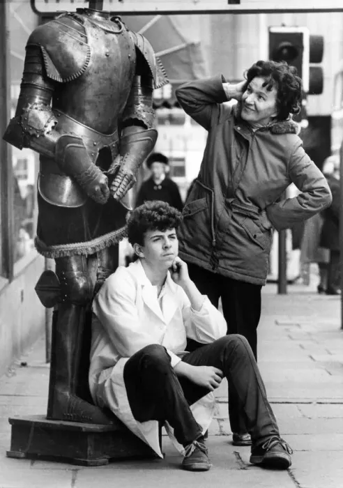 Framed Print : Sales assistant Tommy Frances guards a suit of armour as passers by look in in puzzlement Framed Print : Sales assistant Tommy Frances guards a suit of armour as passers by look in in puzzlement