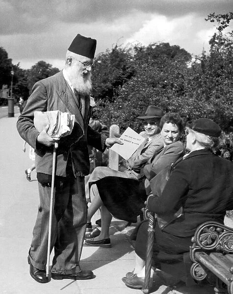 A salesman offering religious text to people sitting on a bench in Hampstead Heath