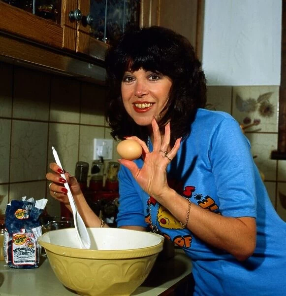 Sally James in kitchen making cake September 1981