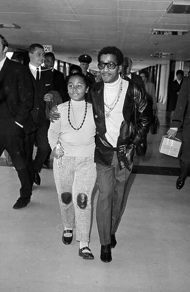 Sammy Davis Jnr arriving at Heathrow with Egey Rhodes the daughter of his band leader
