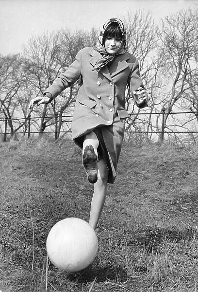 Sandie Shaw, singer, pictured kicking a ball March 1965