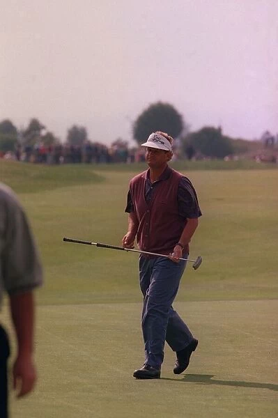 Sandy Lyle golfer on green carrying putter wearing skip cap at Gleneagles golf course