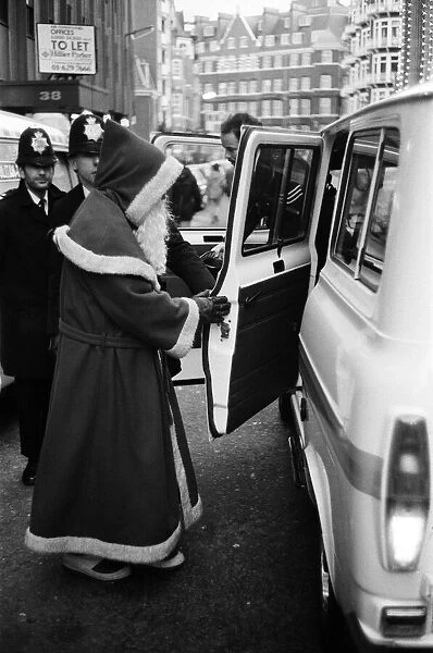 Santa is arrested by policeman for obstruction. He had been offering to pose with passers